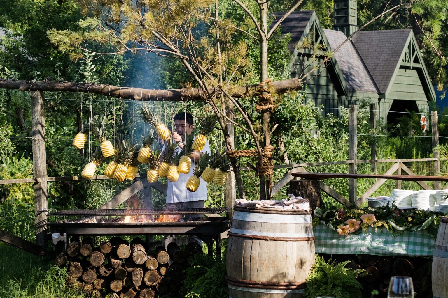 Pineapples smoking over an open flame at a Chef Alex Chen fire-cooking event