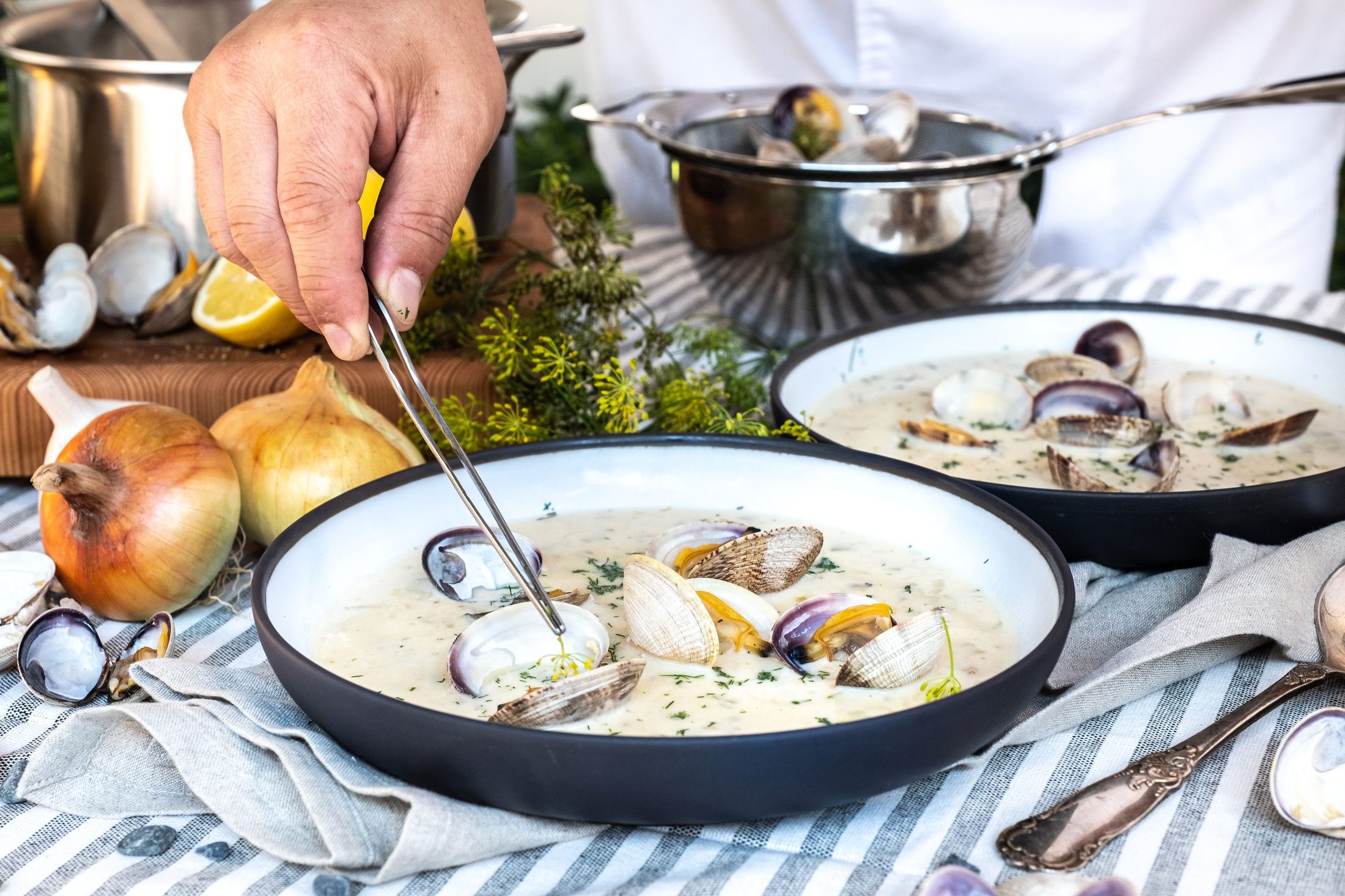 Chef Alex Chen plating clam chowder with fresh littleneck clams