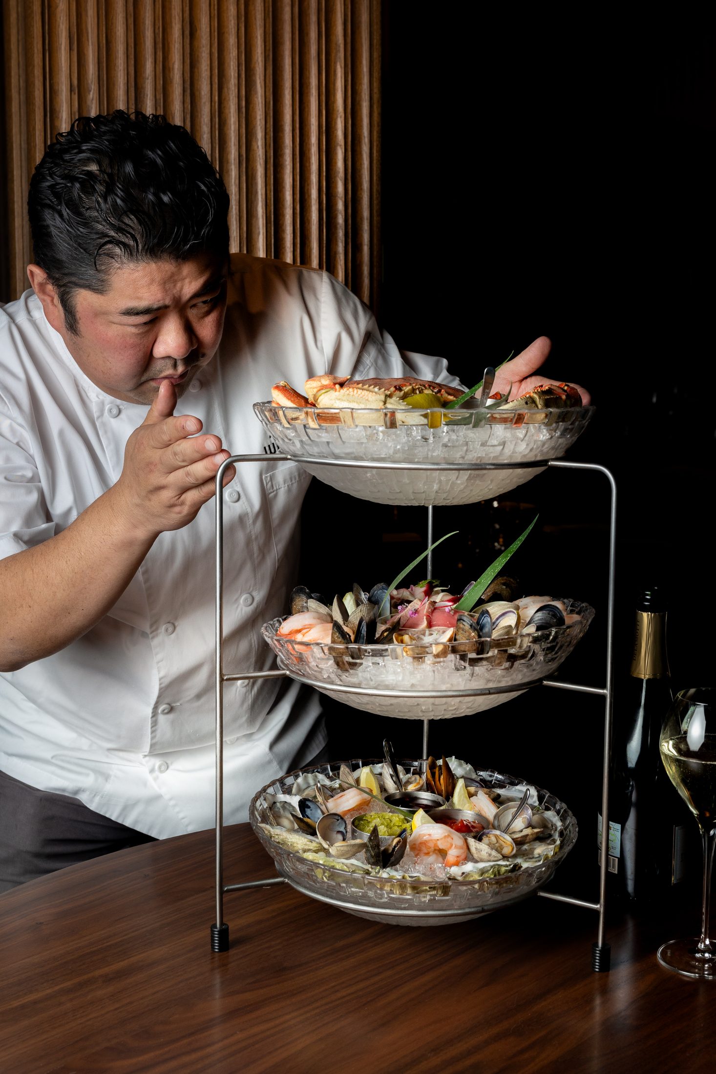 Chef Alex Chen presenting a three-tier seafood tower