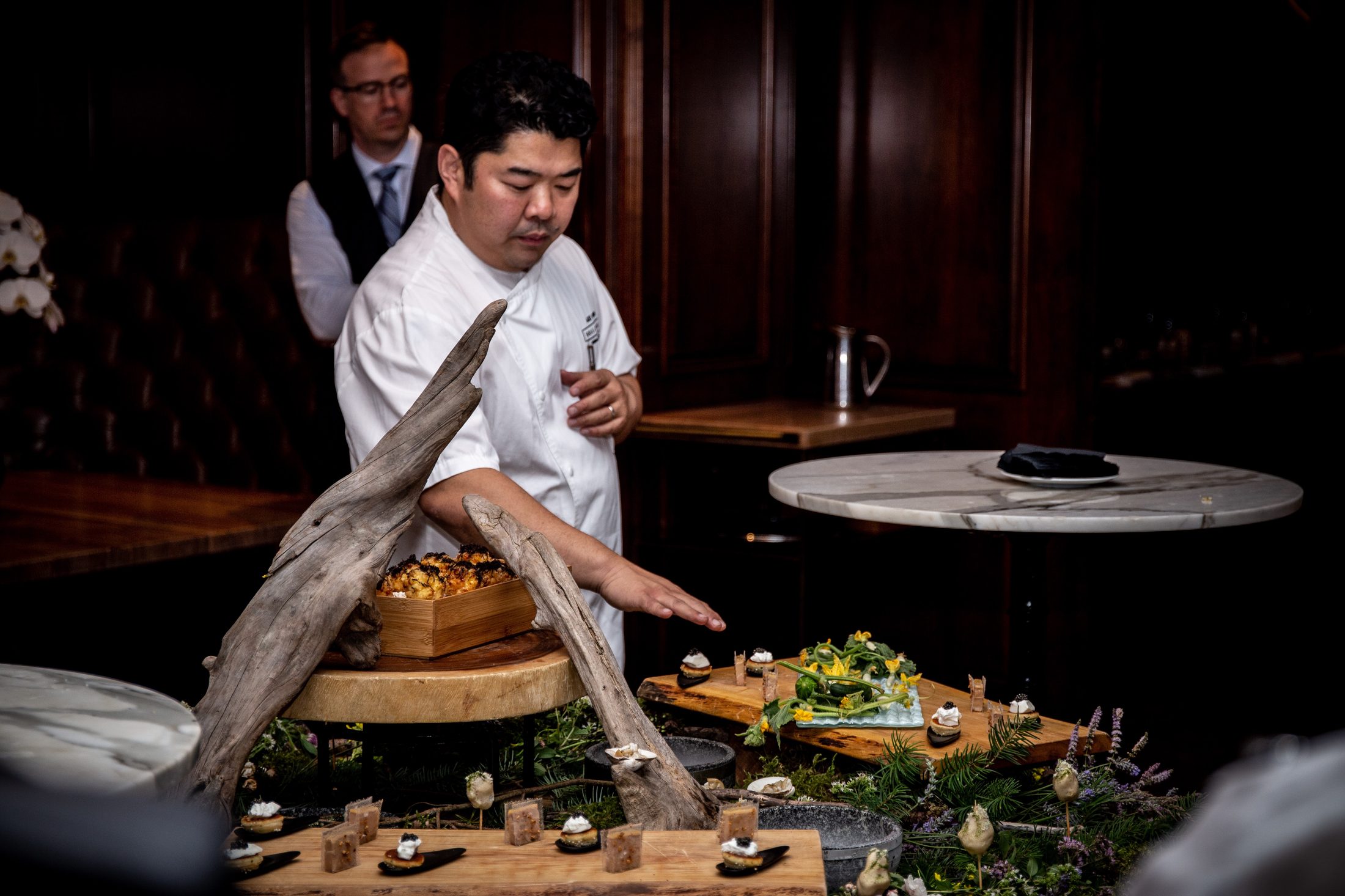 Chef Alex Chen presenting a foraged tablescape of canapés for TableOne