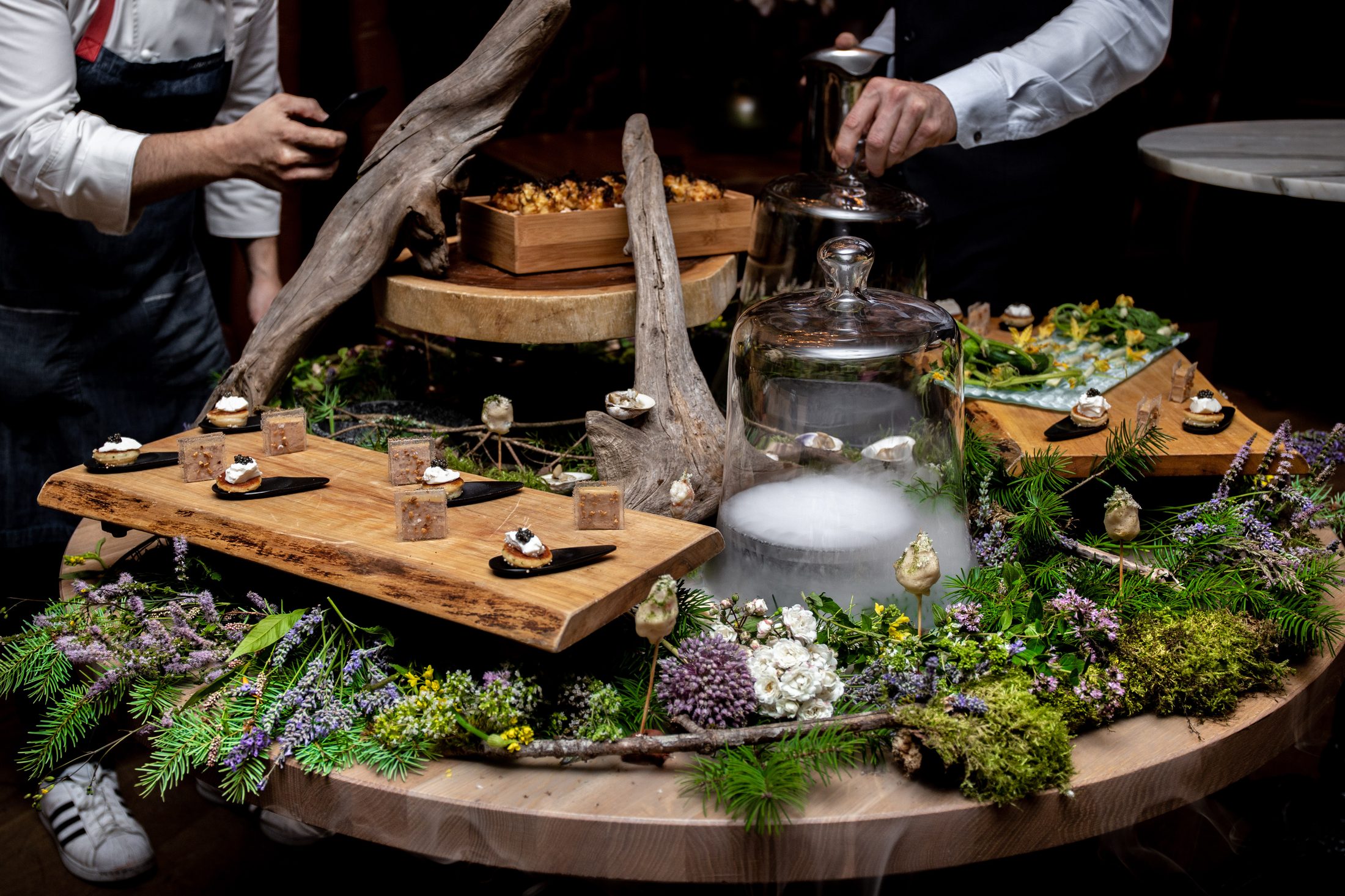 Chefs preparing canapés on a foraged tablescape for TableOne