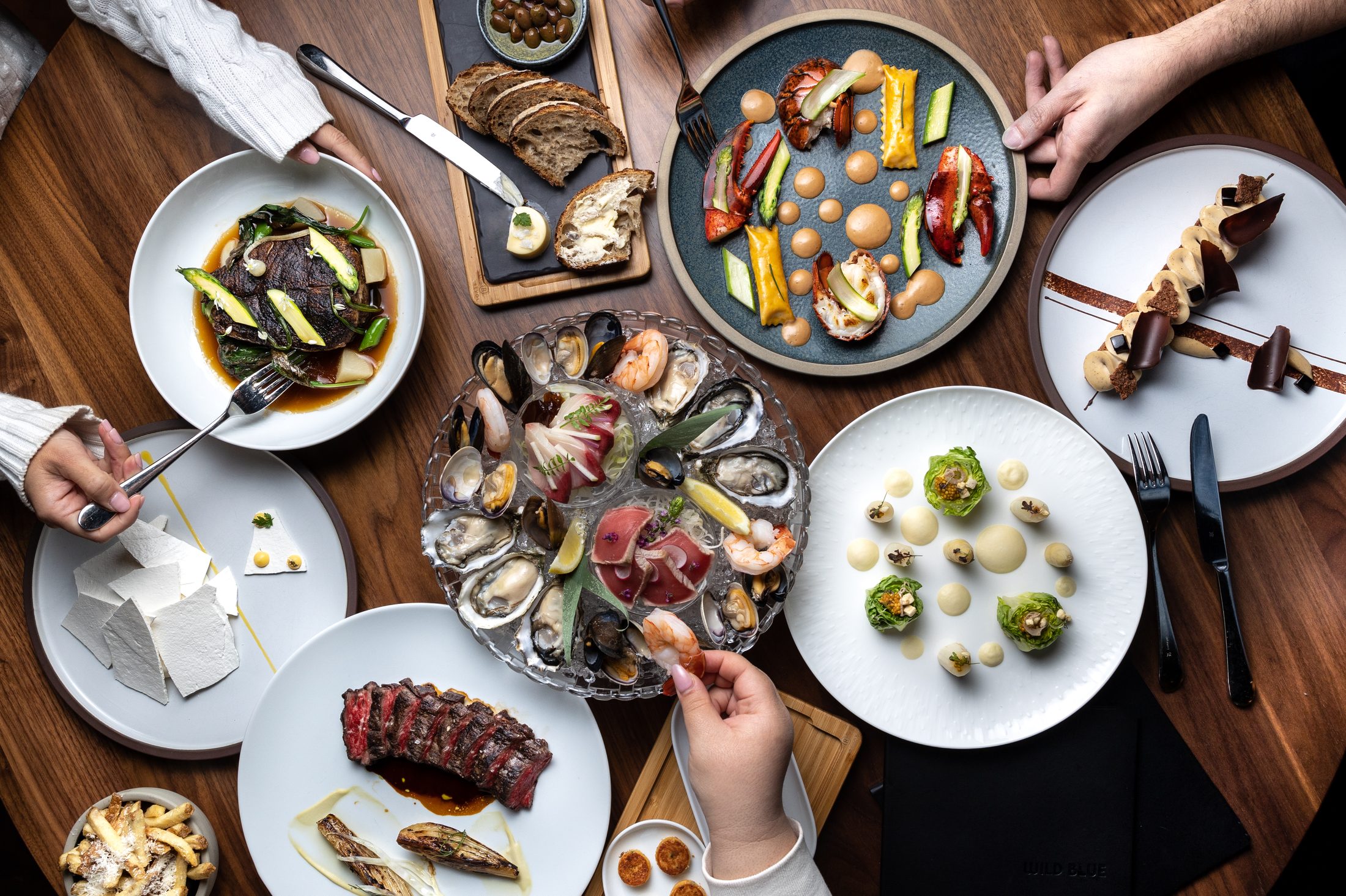 A spread of dishes from Wild Blue Restaurant + Cocktail Bar